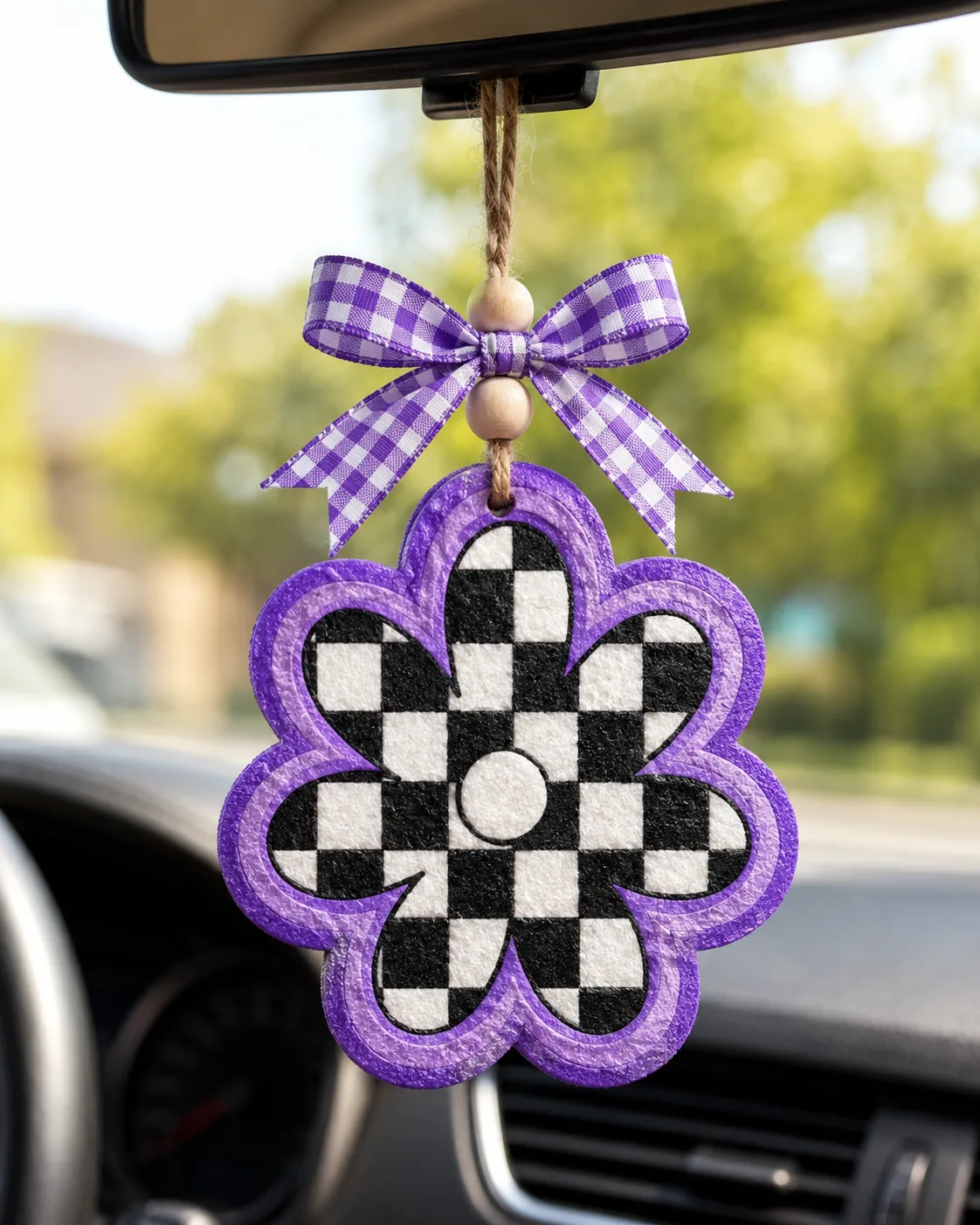 Handmade checkered daisy freshie car air freshener with a white daisy flower on a retro black and white checkerboard pattern, hanging from a ribbon.