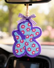 Handmade flower balloon animal car freshie shaped like a floral balloon dog aroma bead air freshener hanging from a car rearview mirror.