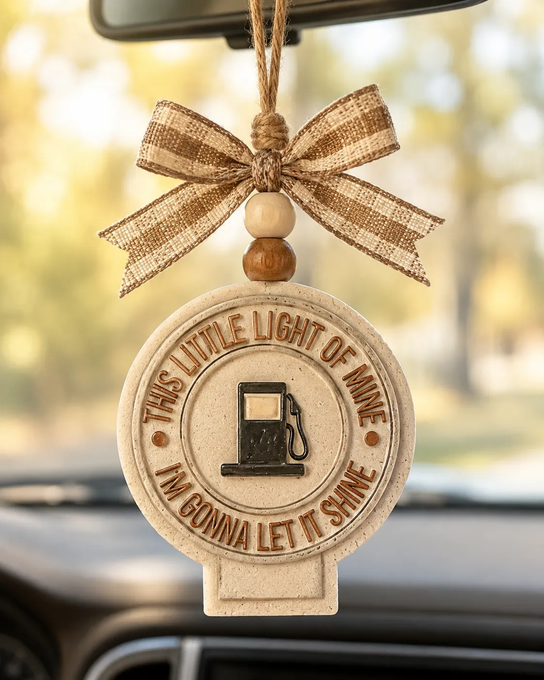 Handmade sun-shaped aroma bead car freshie with "Let It Shine" faith lettering, a boho sunshine air freshener hanging from a car rearview mirror.