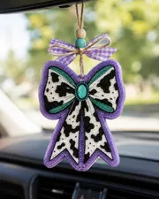 Retro western cow print bow-shaped car freshie air freshener made of scented aroma beads, hanging from a rearview mirror with a cowgirl country style.