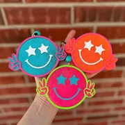 Handmade scented aroma bead car freshie air freshener shaped like a round retro smiley face with puffy star eyes and little hands throwing peace signs, hanging from a beaded cord.